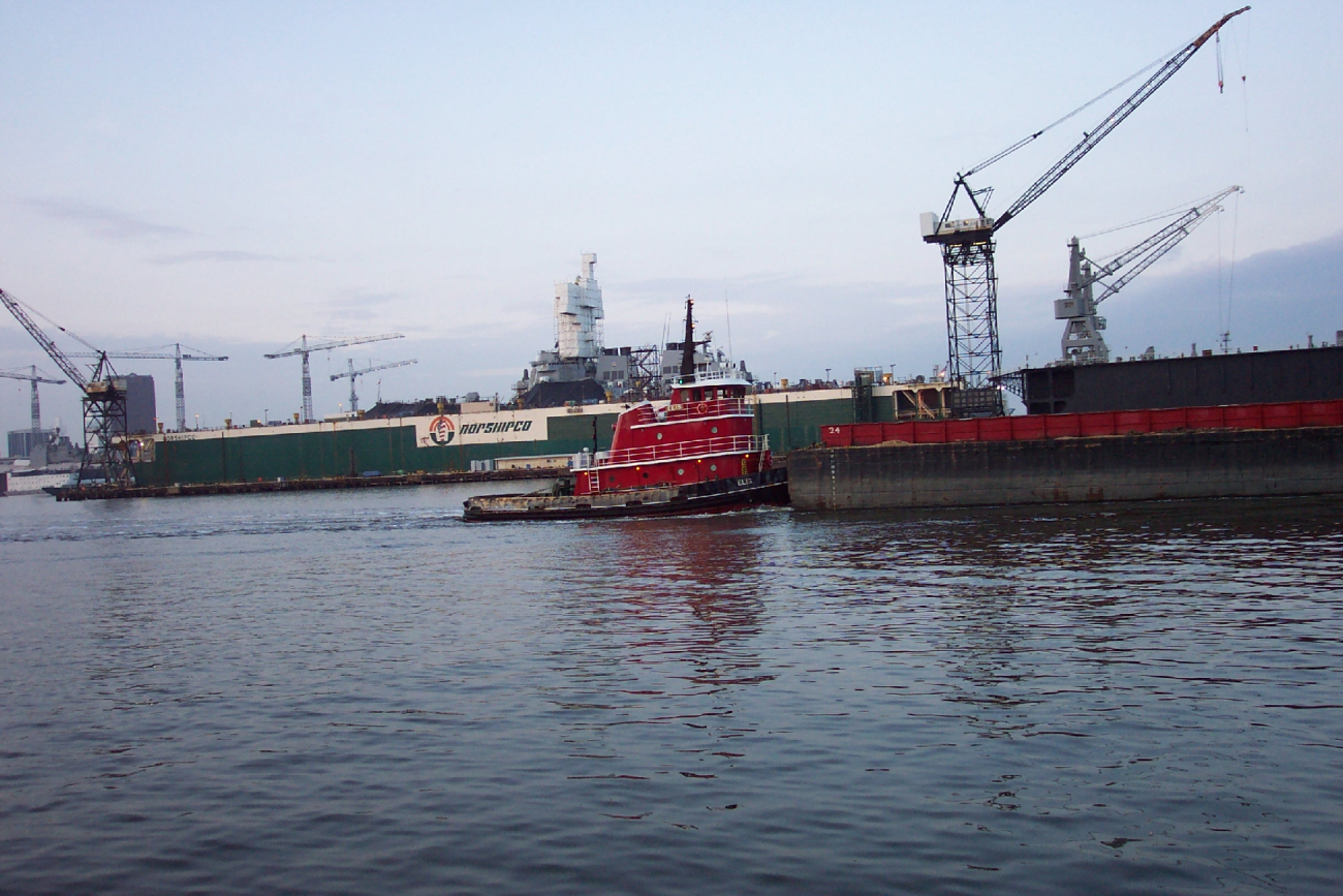 Tug pushing barge down the Elizabeth River with Navy ship in drydock (Image credit: Captain Albert E. Theberge) Tug pushing barge down the Elizabeth River with Navy ship in drydock