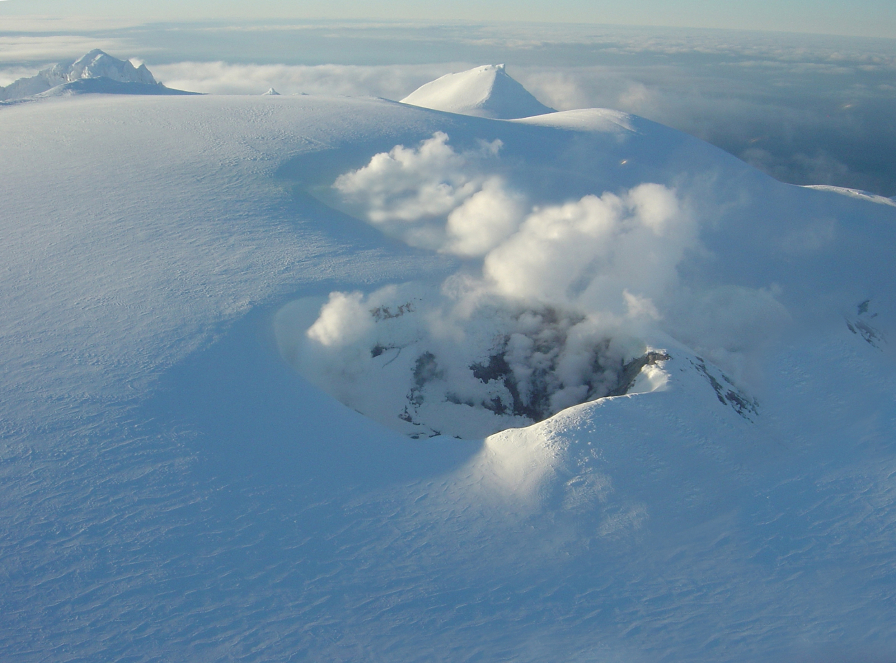 A snow-shrouded Makushin Volcano emits steam and volcanic gases meltingaway the snow in the caldera (Image credit: Doug Helton) A snow-shrouded Makushin Volcano emits steam and volcanic gases meltingaway the snow in the caldera