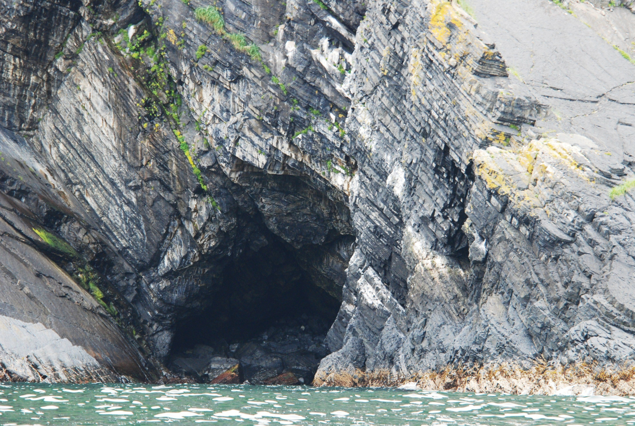 Tilted sedimentary beds and a large sea cave (Image credit: Ensign Patricia Raymond) Tilted sedimentary beds and a large sea cave