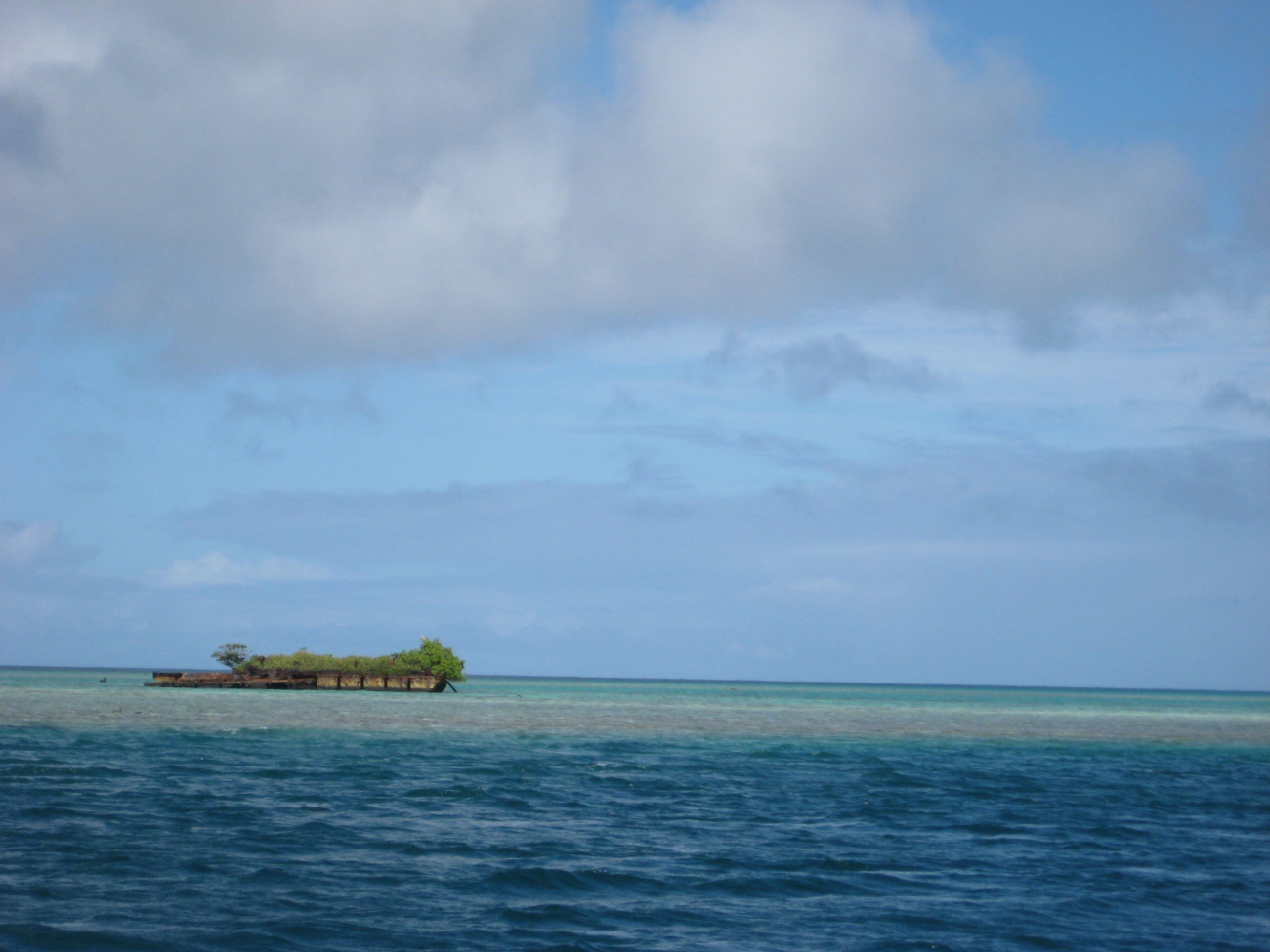 A deserted barge left on the reef which has become a vegetated islet (Image credit: LCDR Eric Johnson) A deserted barge left on the reef which has become a vegetated islet