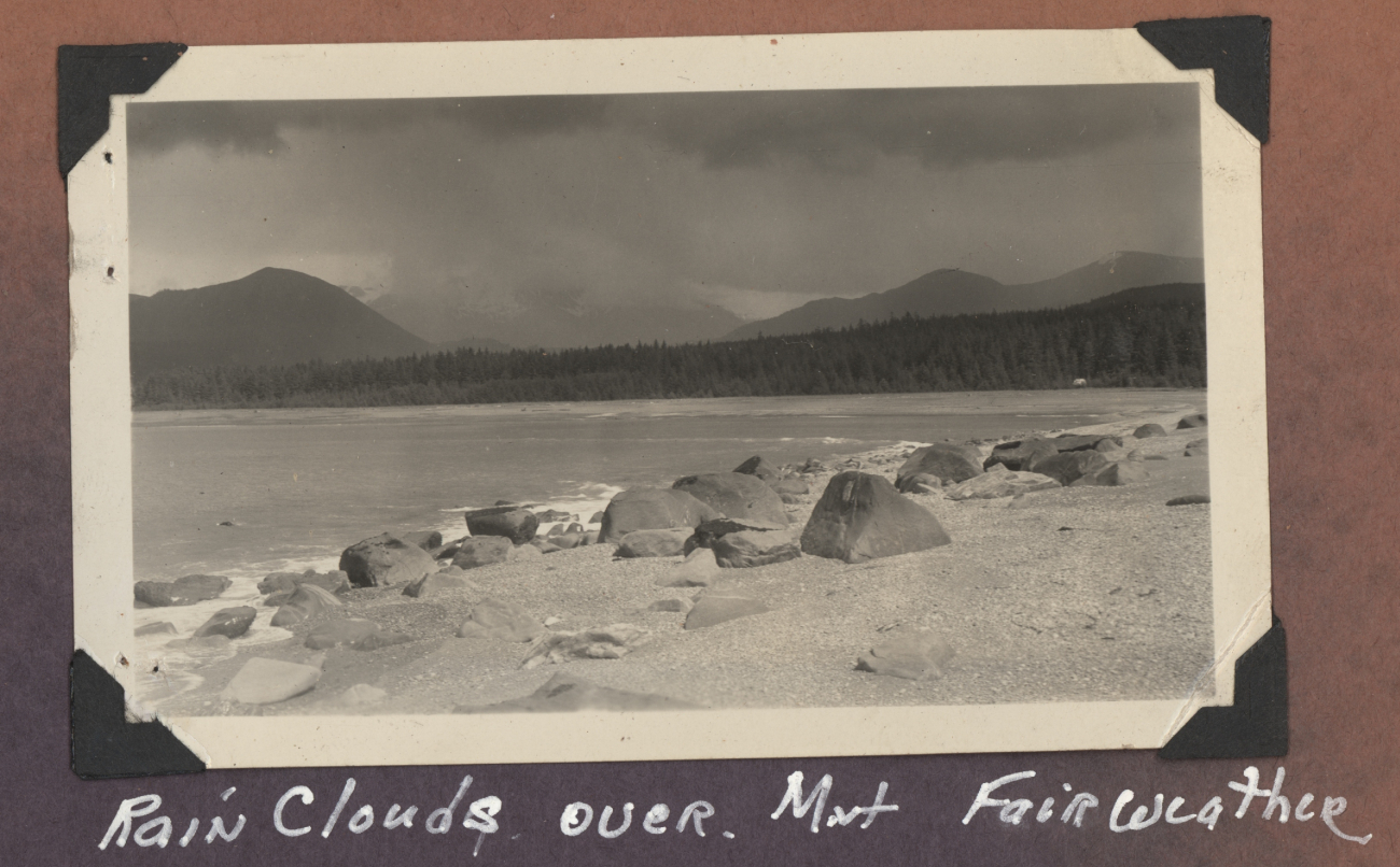 Looking over a sand and boulder beach to Mount Fairweather enveloped inrain clouds (Image credit: Courtesy of the Family of Robert Gholston, C&GS; surveyor) Looking over a sand and boulder beach to Mount Fairweather enveloped inrain clouds