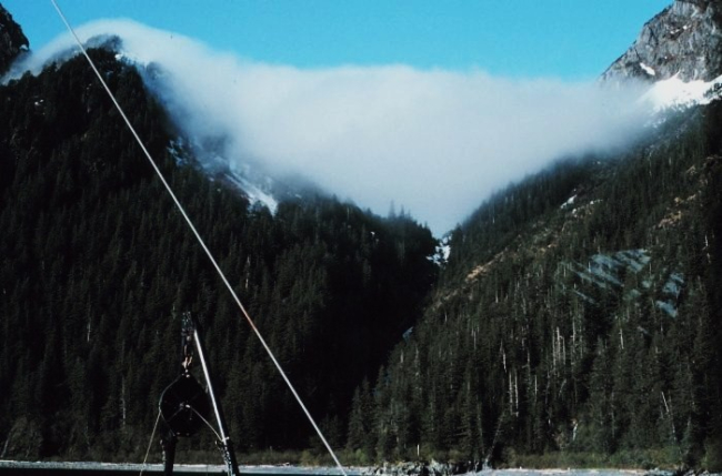 Fog tumbling through a break in the mountains at Prince William Sound