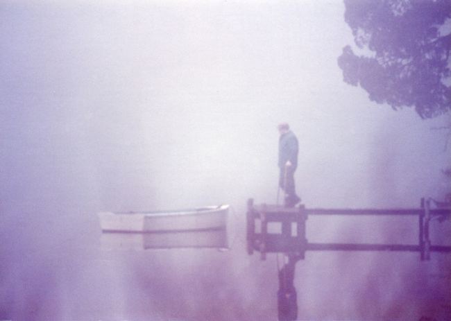 Fisherman checking his boat on a foggy morning
