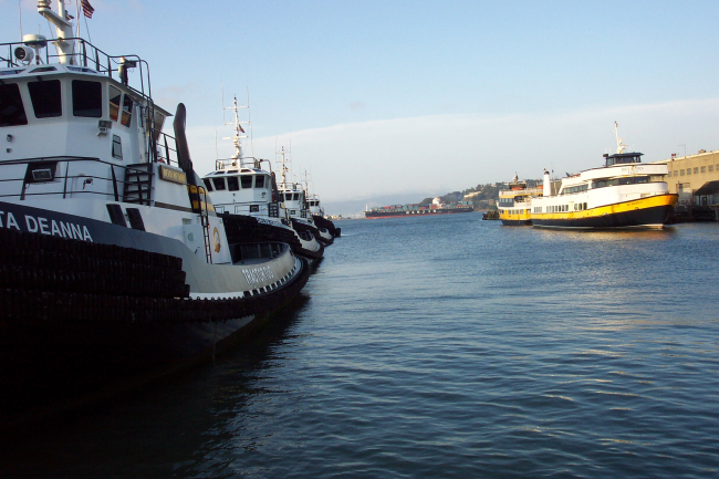 A container ship heads up the bay as framed between Tractor Tugs and bay tourboats