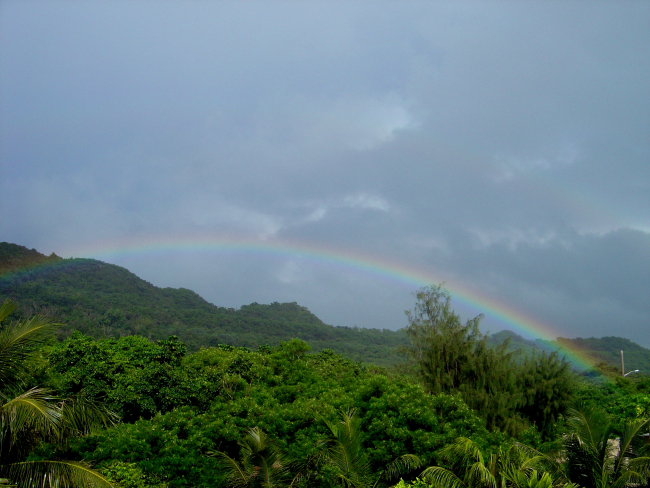 A rainbow graces the jungle foliage of the Guam mountains