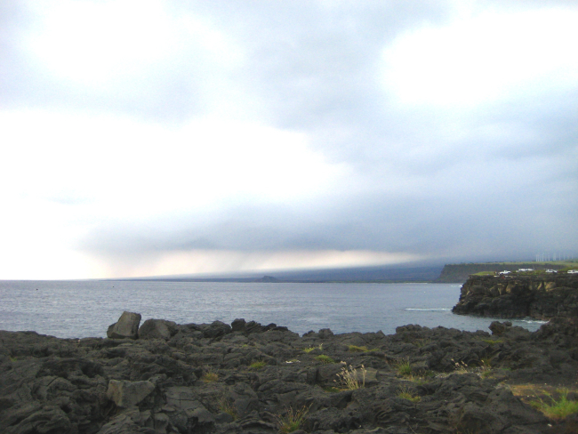 Volcanic cliffs with wind farm in the distance