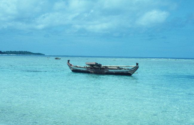 A native outrigger anchored inside the reef line of a Caroline island