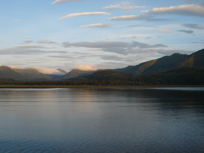 Mountains rise above a quiet Kodiak Island cove at the end of the day