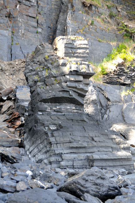 Where the sea ends on the banded rock cliffs of Kodiak Island