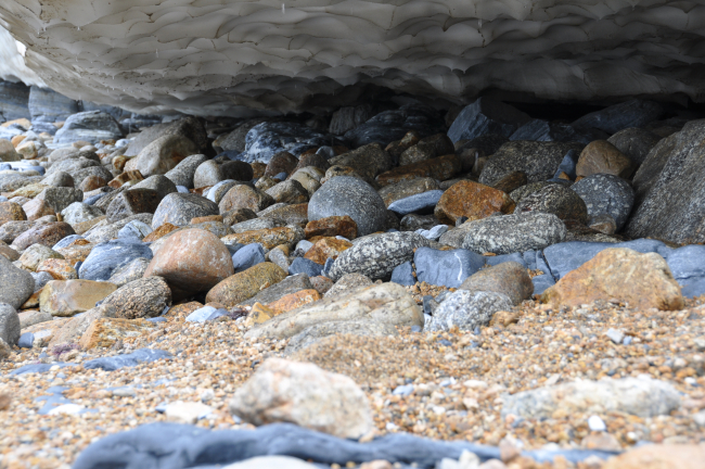 Below the melting ice surface lie rounded boulders, attesting to the violence of Bering Sea surf near Tin City and Cape Prince of Wales